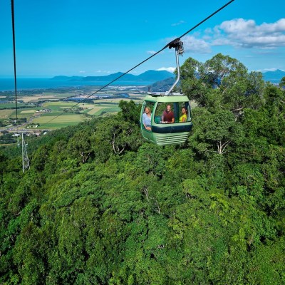 a boat on the grass with Skyrail Rainforest Cableway in the background